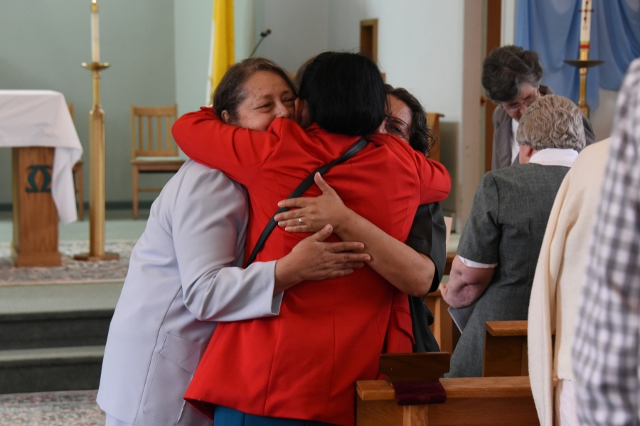 Sister Elsa and Sister Miriam receive a hug from a woman.