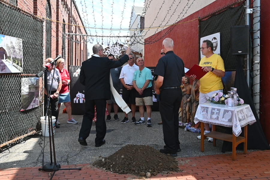 Bishop Ruggieri sprinkles the area with holy water.