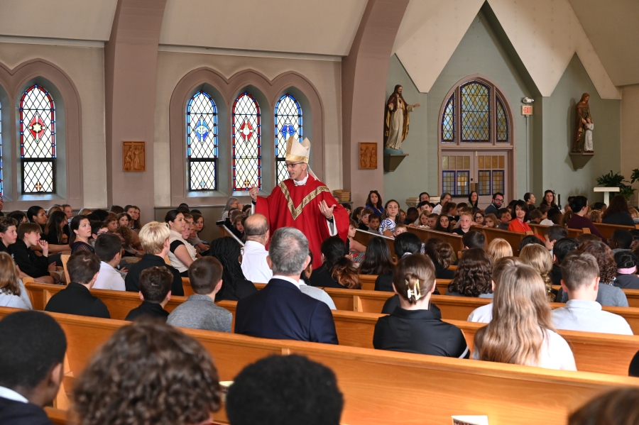 Bishop Ruggieri talking to students during Mass 