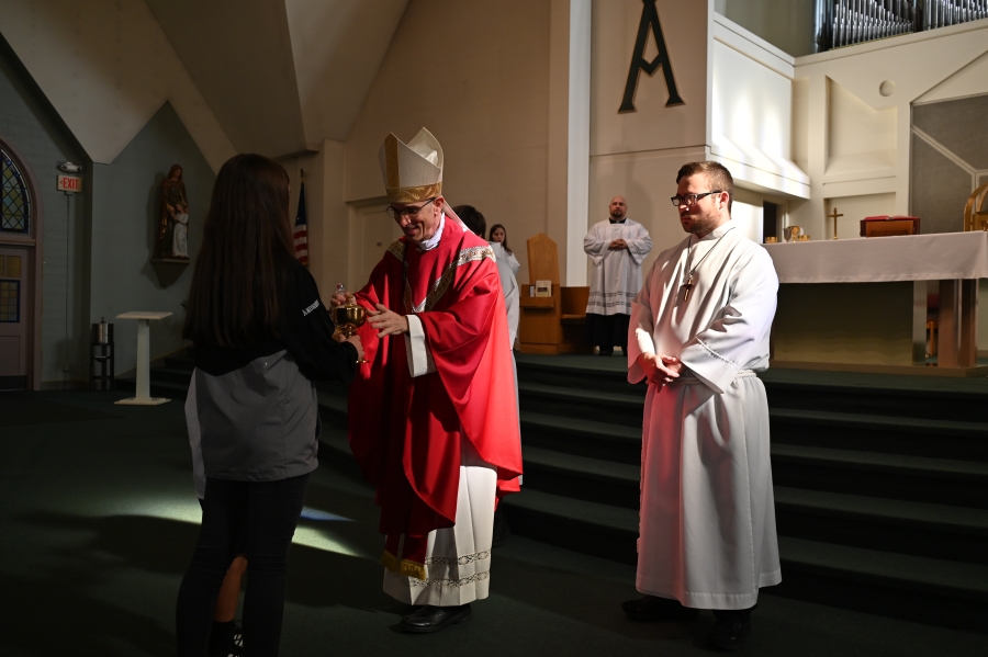 students bringing up gifts during Mass to Bishop Ruggieri 