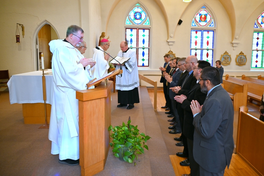 Deacon Peter Bernier with deacon candidates lined up at the foot of the sanctuary.