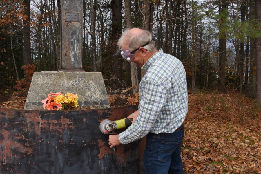 George Janosco works on the base of the crucifix at Mount Calvary Cemetery in Lisbon Falls.