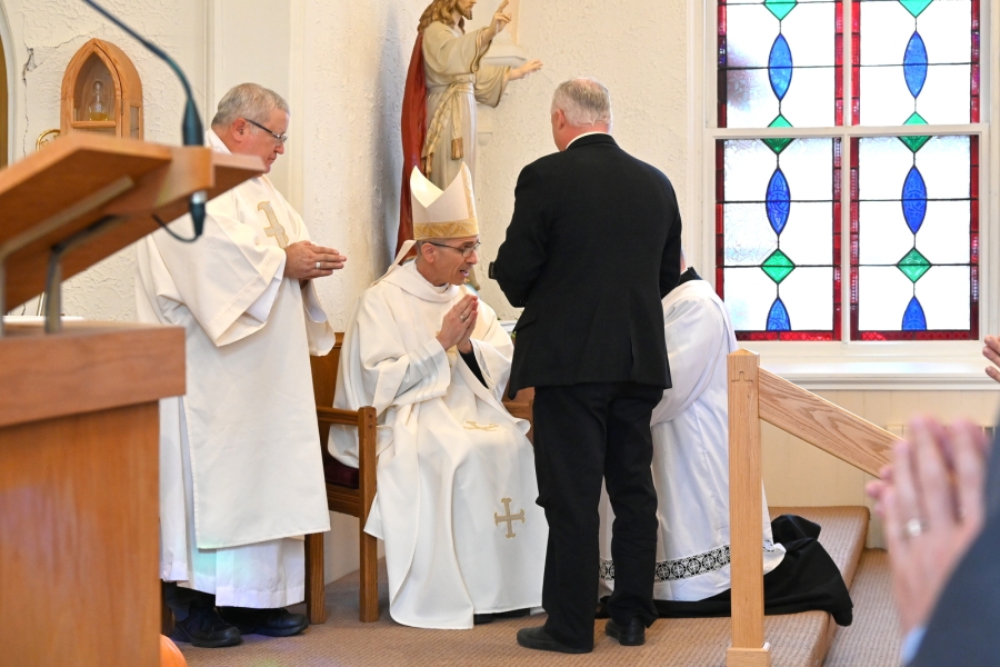 Adam Stearns receives a Bible from Bishop James Ruggieri.