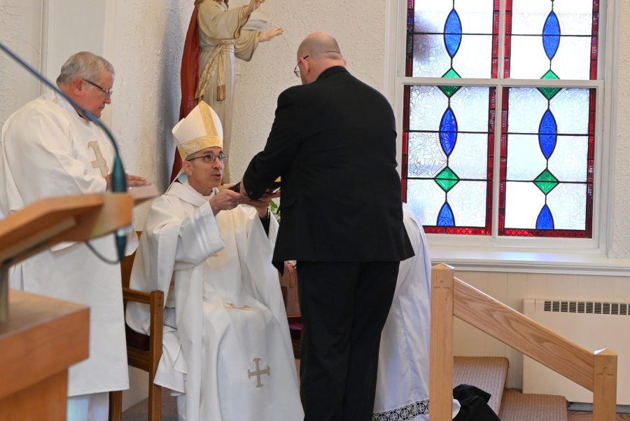 Doug Guerrette receives a Bible from Bishop James Ruggieri.