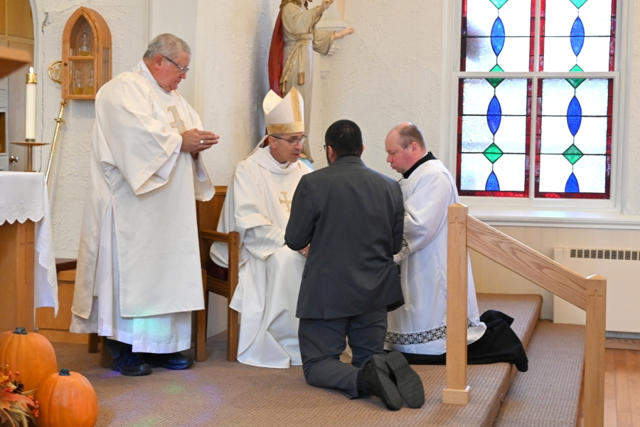 Arturo Ayala receives a Bible from Bishop James Ruggieri.