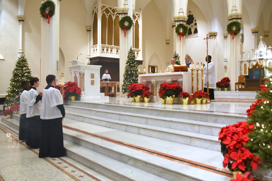 Bishop Ruggieri celebrates the Liturgy of the Eucharist. Altar servers are at the foot of the steps of the sanctuary.