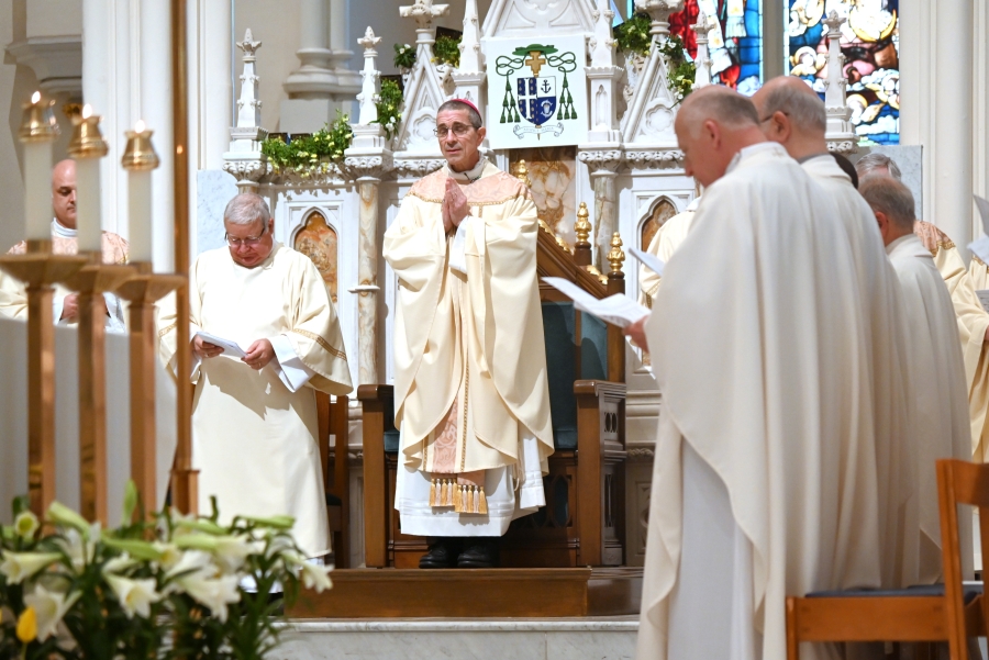 Bishop James Ruggieri at the cathedra with priests at his side