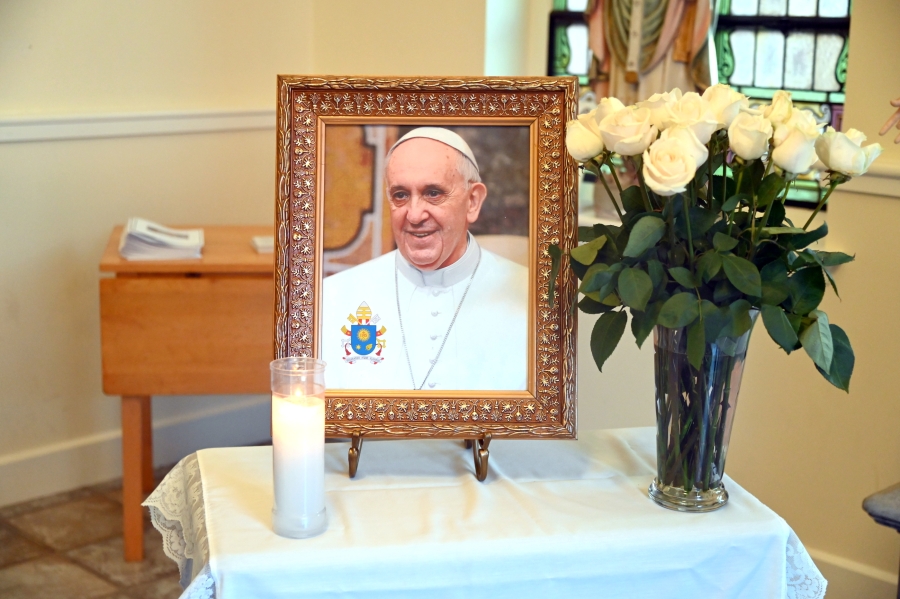 Picture of Pope Francis with flowers next to it.