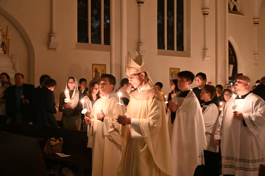 Priests process with lit candles