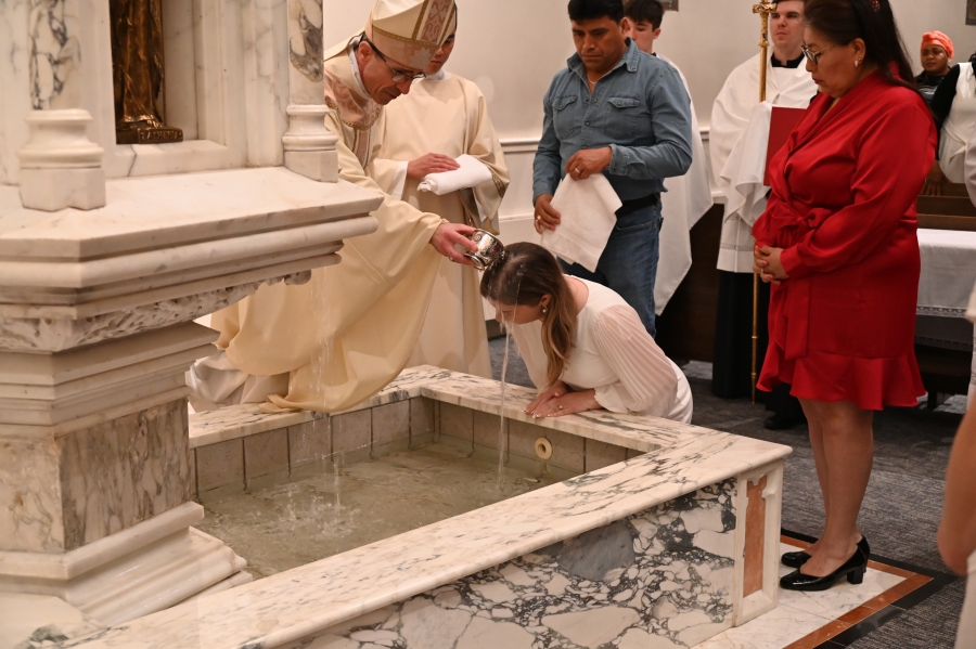 Bishop baptizes woman with water