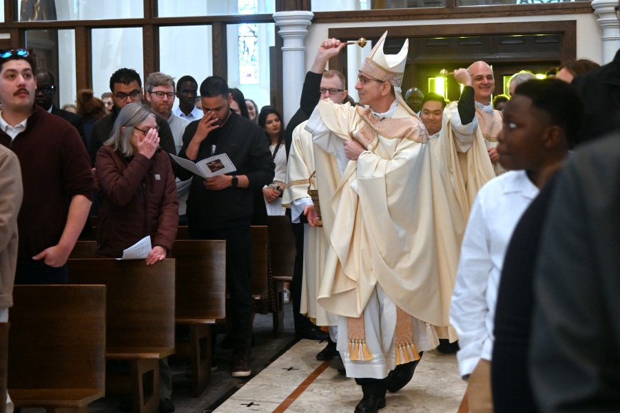Bishop James Ruggieri and Father Seamus Griesbach sprinkle the faithful with holy water.