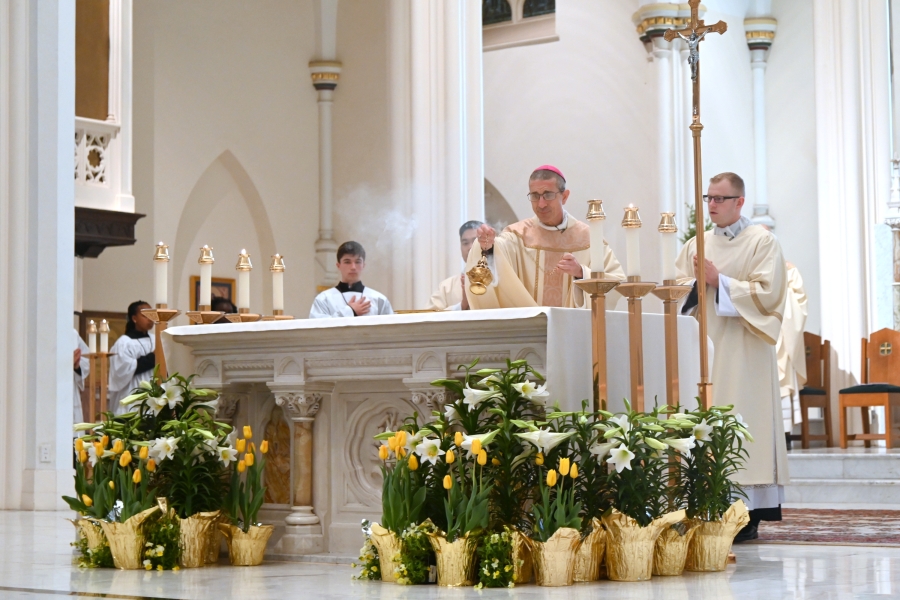 Bishop Ruggieri incenses the altar. Deacon Erin Donlon is standing to his left.