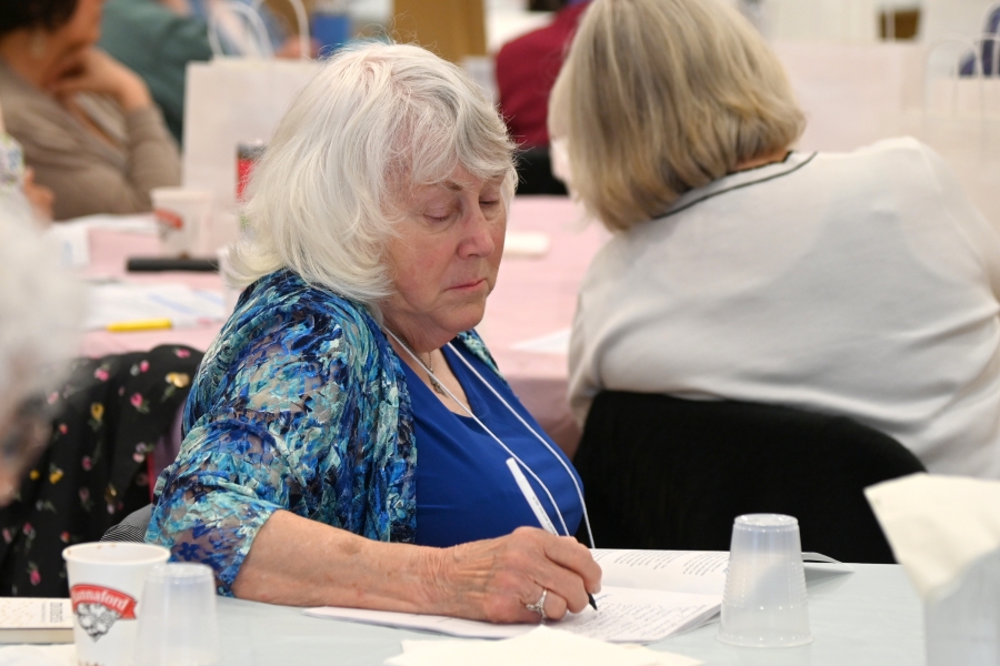 A woman taking notes at a table.
