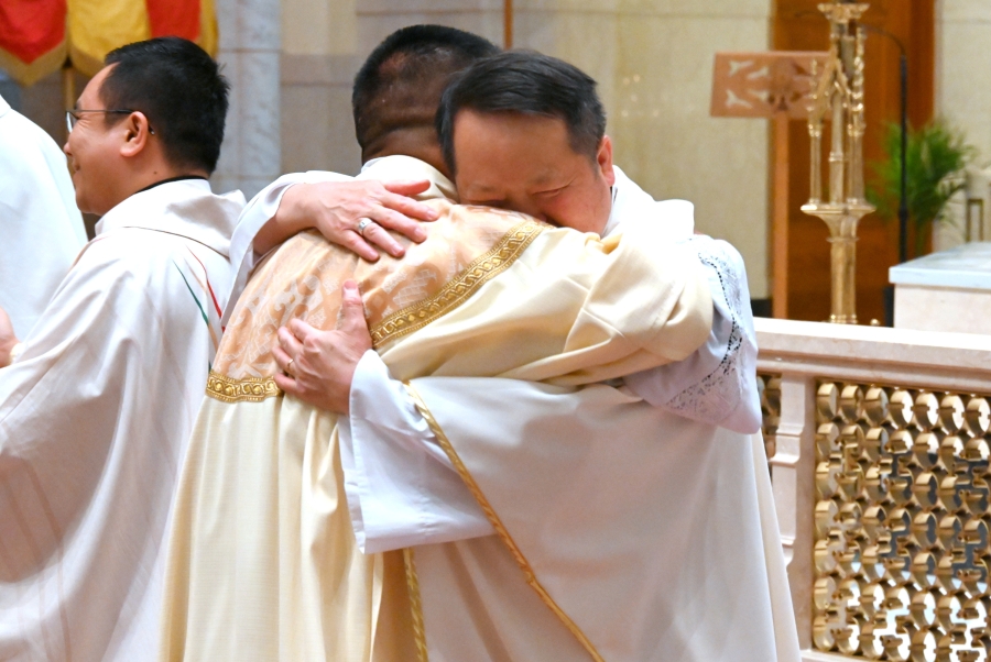 Father Nguyen receives a hug from a Vietnamese priest.