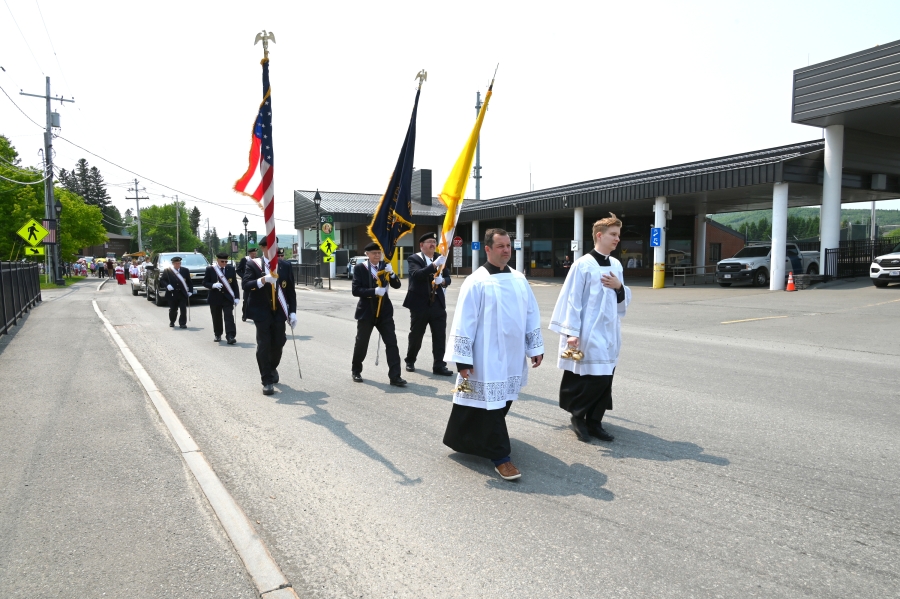 Bell ringers and Knights of Columbus at the lead of the procession.