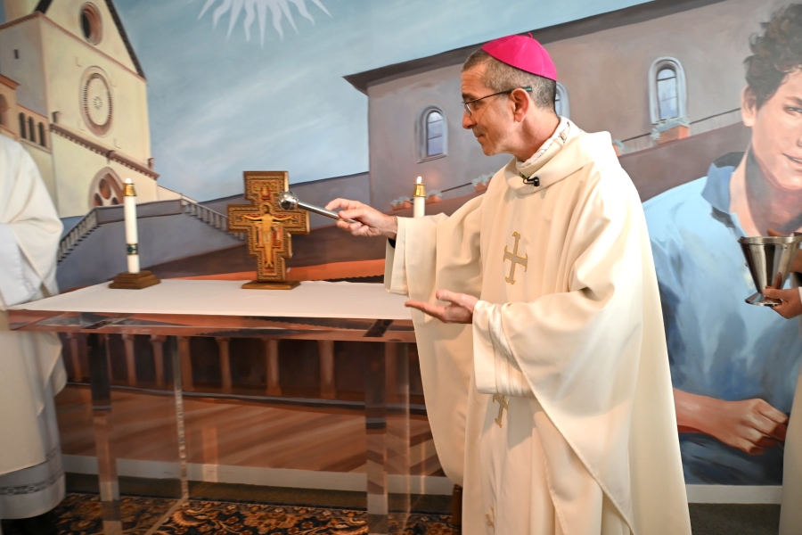 Bishop Ruggieri sprinkling the chapel with holy water