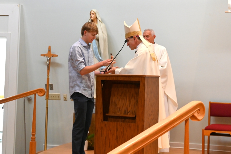 Bishop Ruggieri presents an award to Anselm Arbogast.