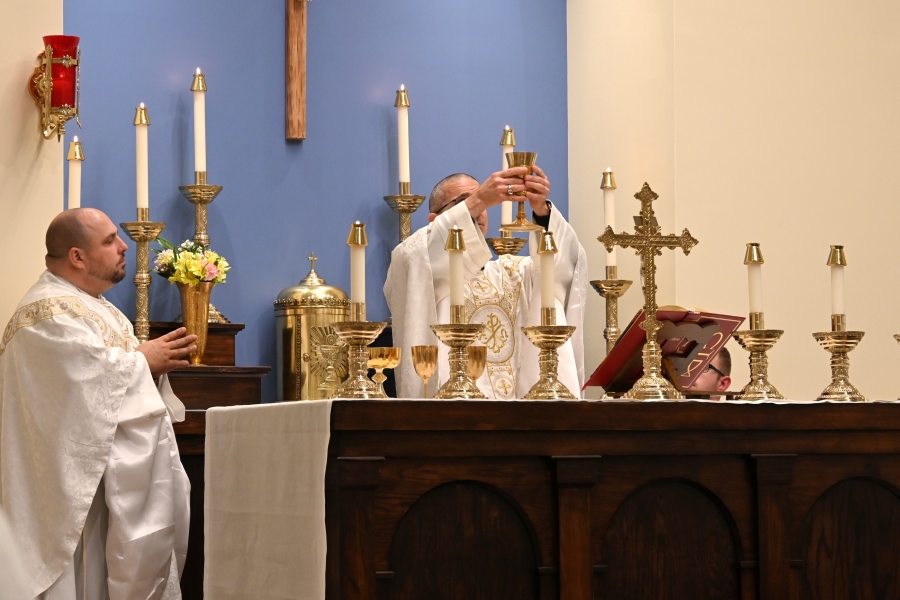 Bishop James Ruggieri holds up the chalice containing the blood of Christ.