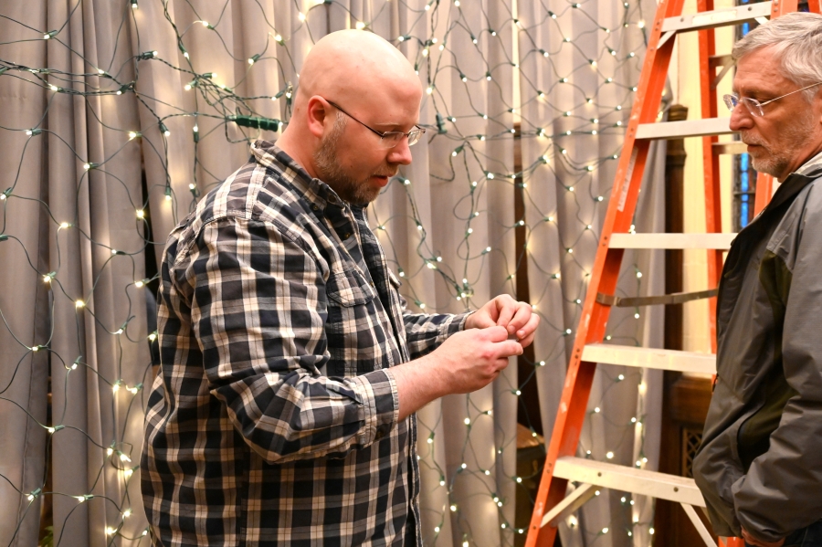 Father Kyle Doustou works on the lighting.