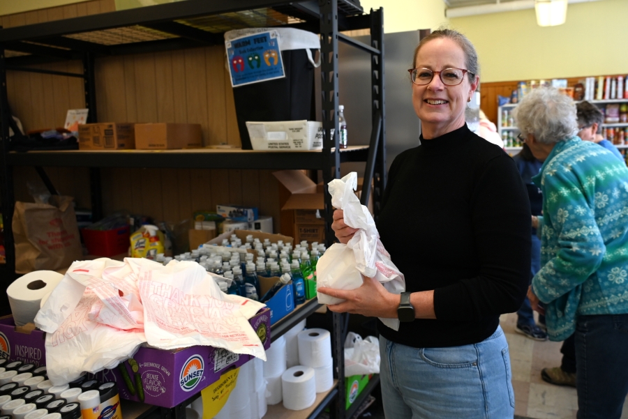 Food pantry volunteer holding a bag of produce.