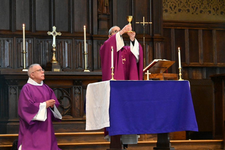 Bishop James Ruggieri holds up the chalice containing the blood of Christ.