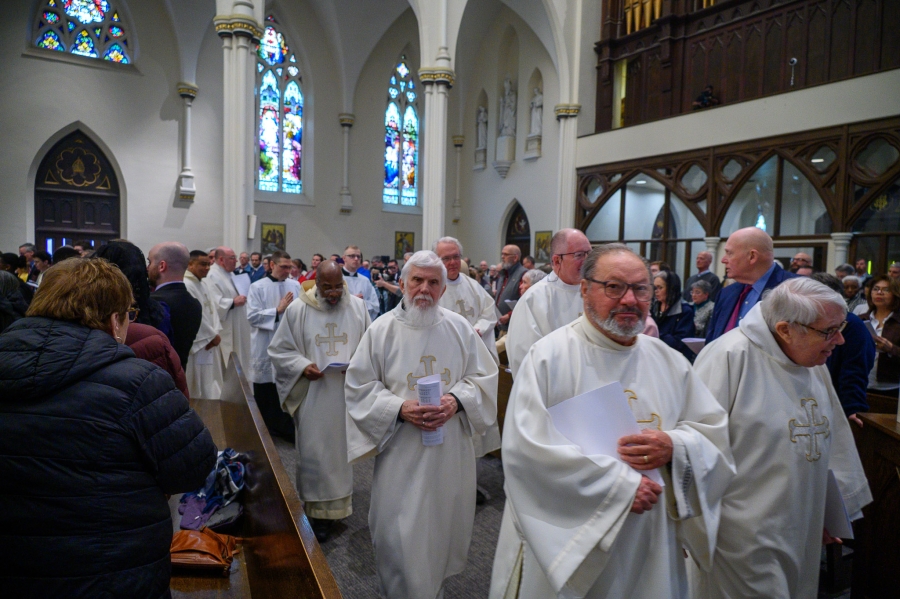 Priests exit after Mass