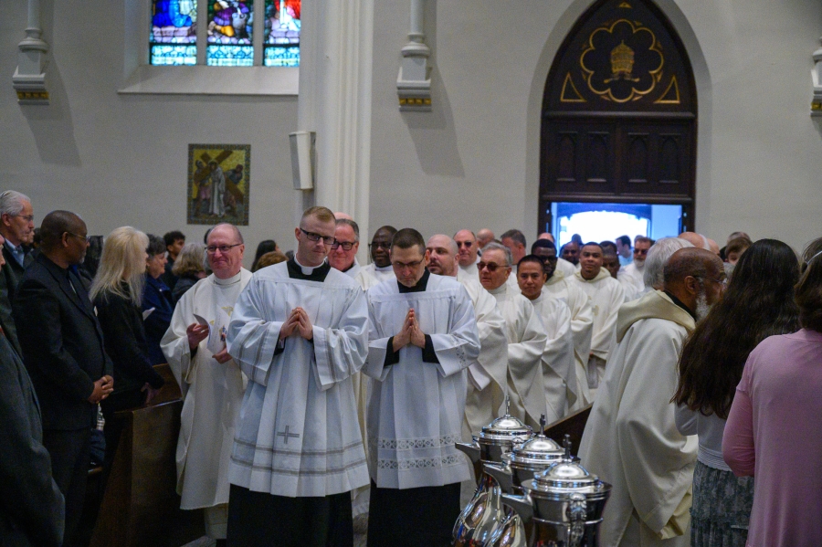 Priests enter Chrism Mass