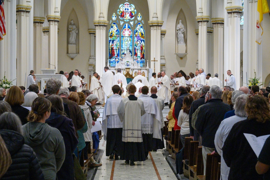 Priests enter Chrism Mass