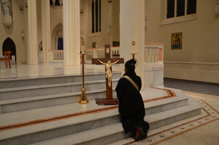 Woman kneeling at the cross.