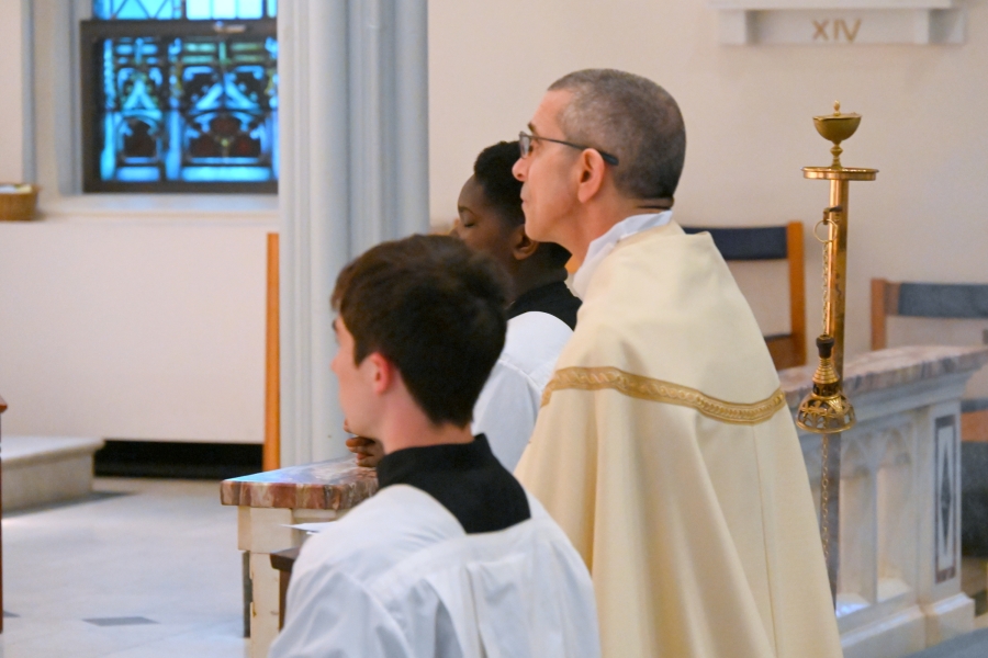 Close up of Bishop Ruggieri kneeling with altar server next to him.