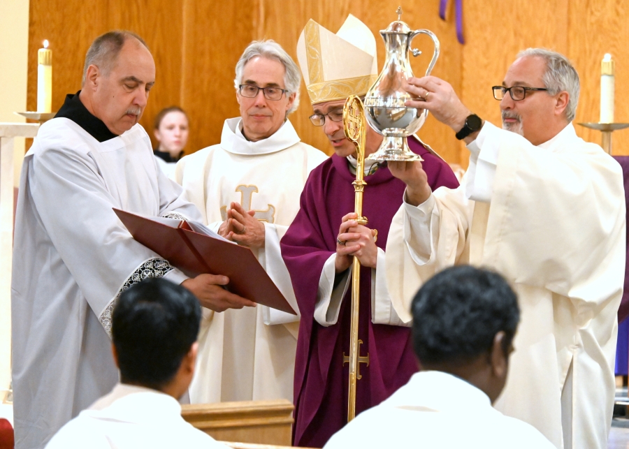 Deacon Rodney Deschaine holds up the sacred chrism.