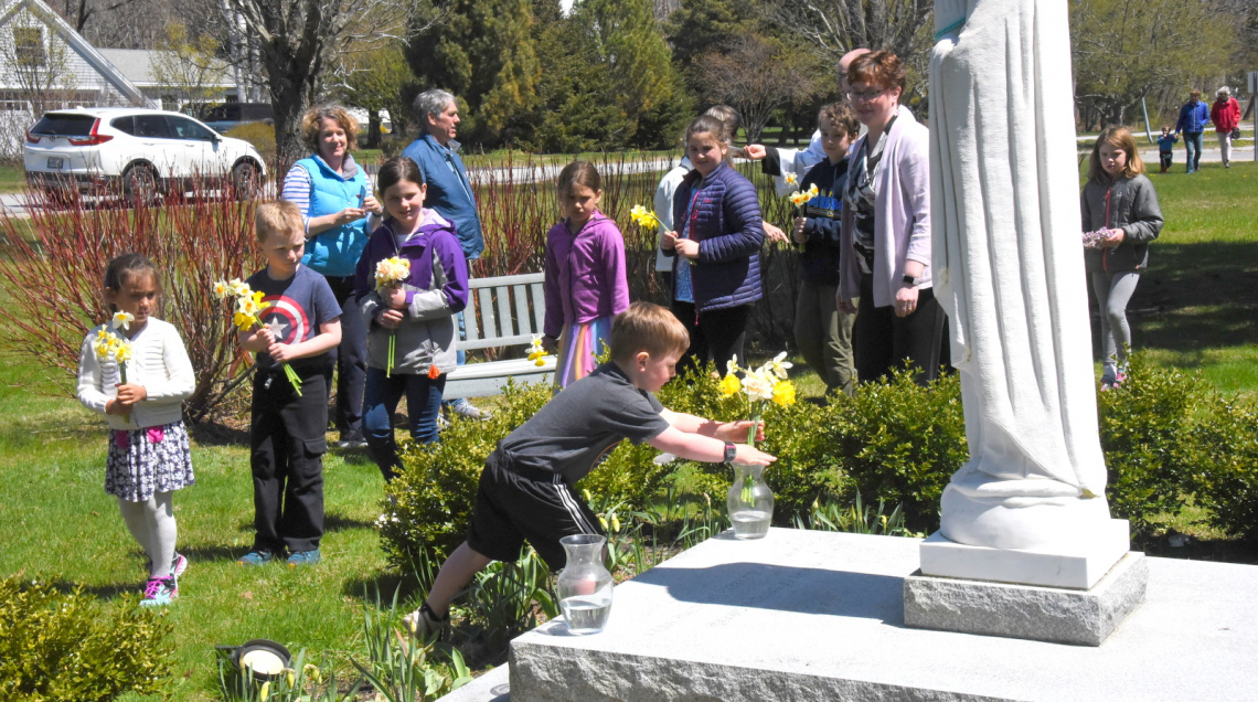 Placing flowers at the foot of the statue of Mary