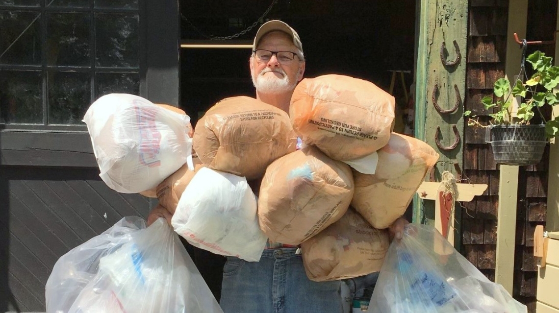 Boyd Smith holding bags of plastic.