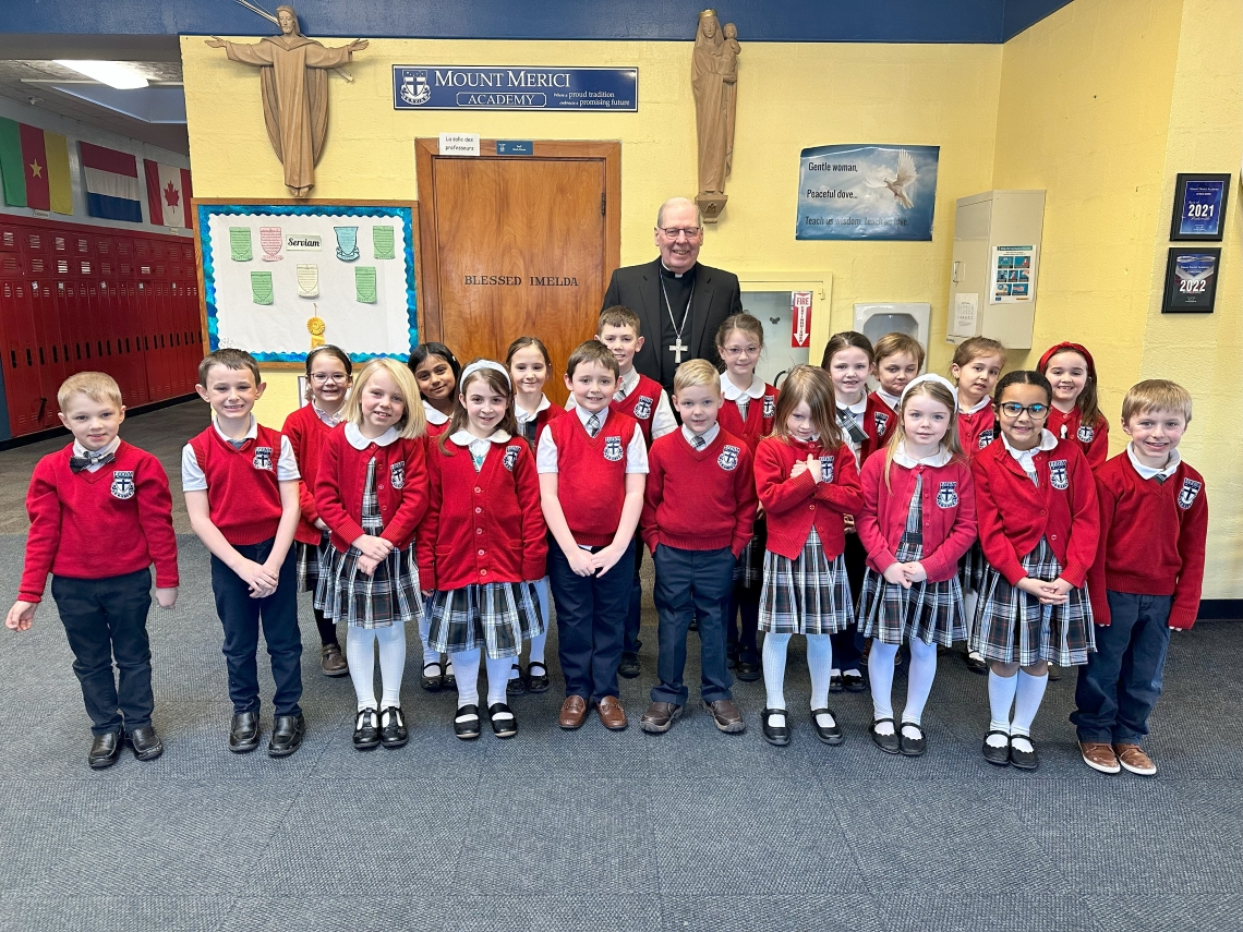 Bishop surrounded by students in red sweaters