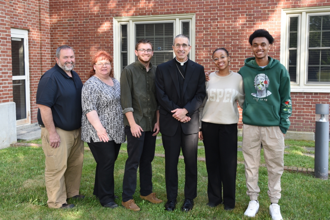 Robert, Jennifer & Ryan Bussiere, Bishop James Ruggieri, and Mimosa Isimbi and her brother, Chelsea.