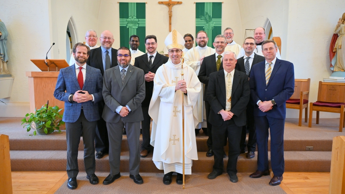 Eight deacon candidates with Bishop James Ruggieri, three priests, two deacons, and Peter Czerwinski.