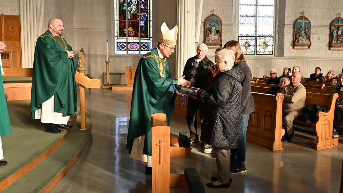 Bishop James Ruggieri hands the Matthew 25 Award to volunteers