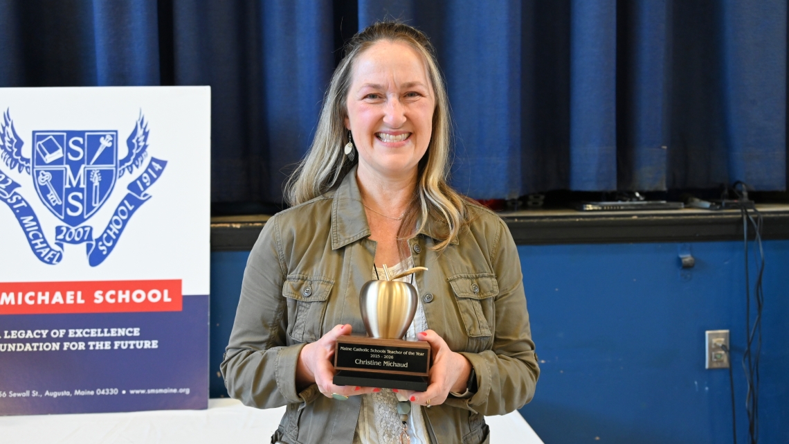 Christine Michaud holding her Teacher of the Year Award.