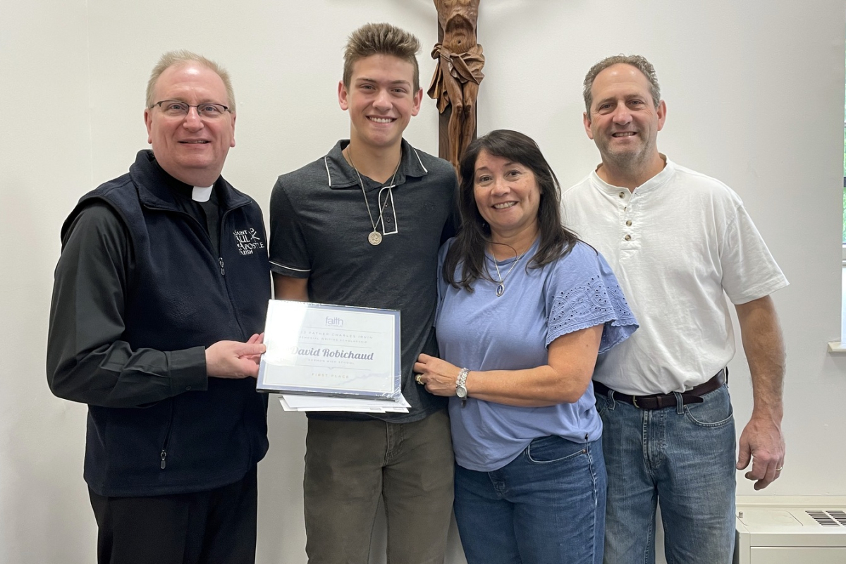 Msgr. Andrew Dubois presents a check to David Robichaud and his family.