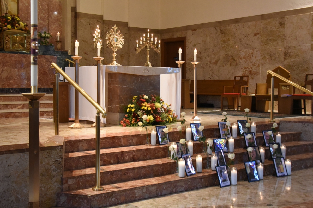 Photos of the 18 shooting victims placed on the stairs of Holy Family Church.