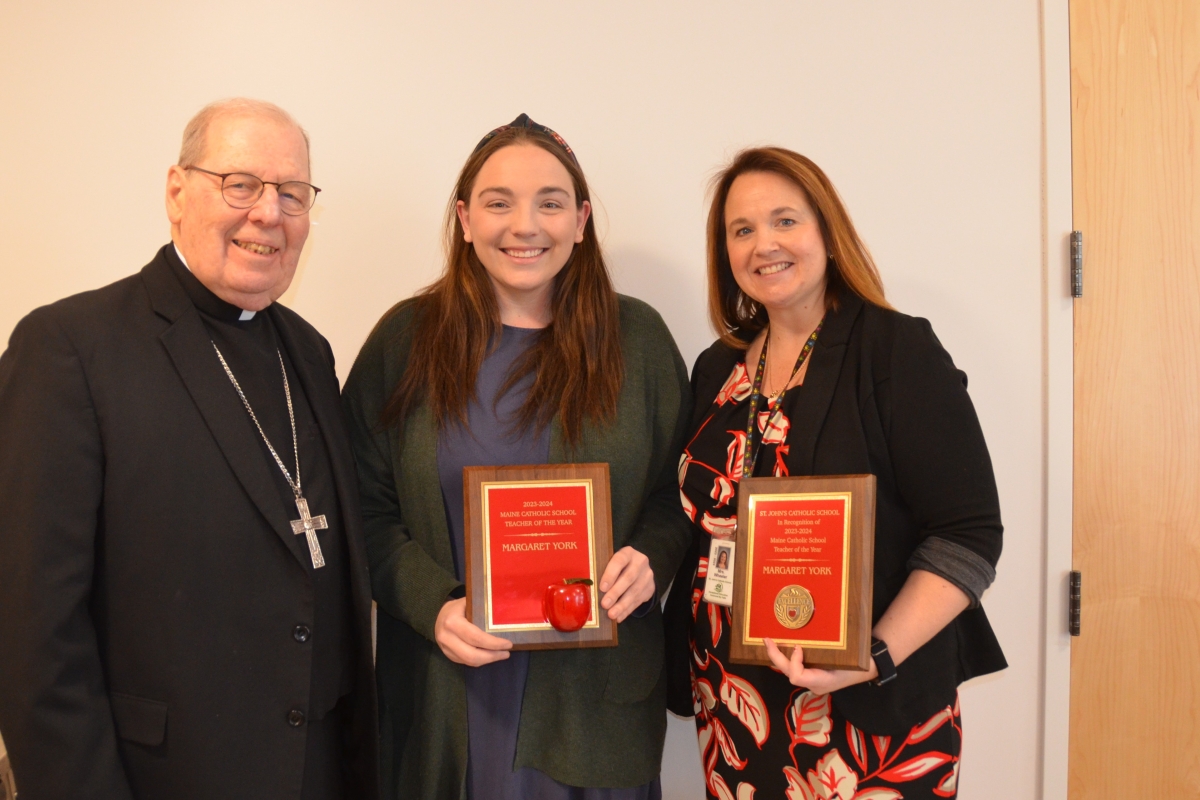 three people holding awards
