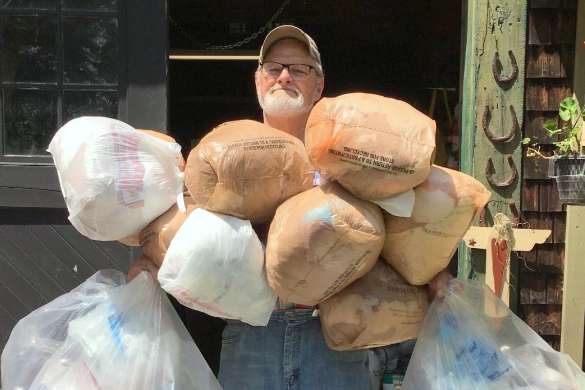 Boyd Smith holding bags of plastic.