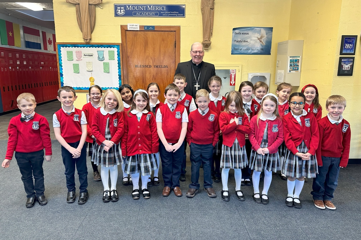 Bishop surrounded by students in red sweaters