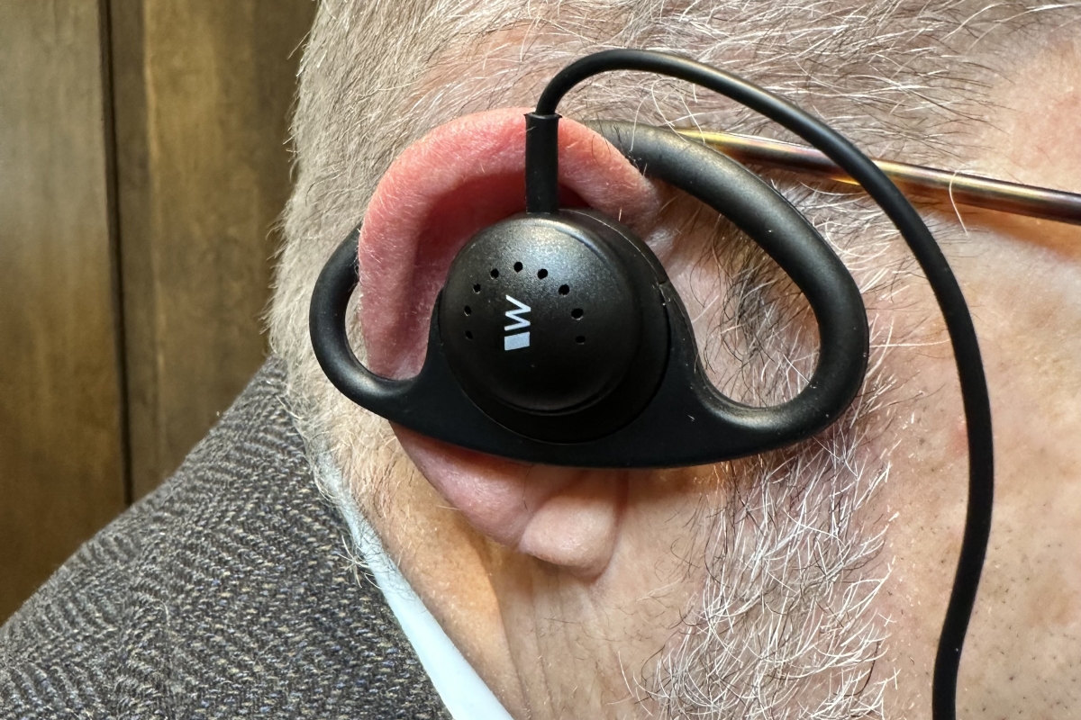 man wearing listening assist device in ear