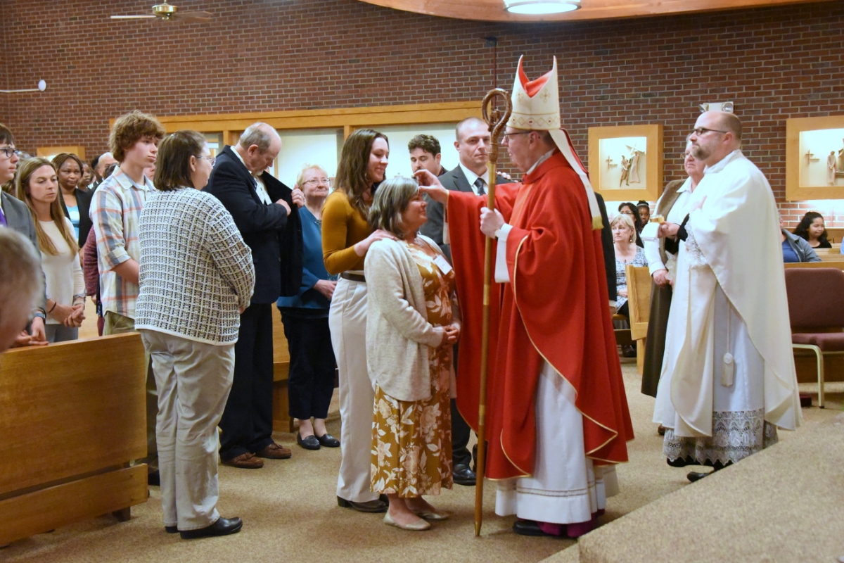 The bishop gives the sacrament of confirmation to a person.