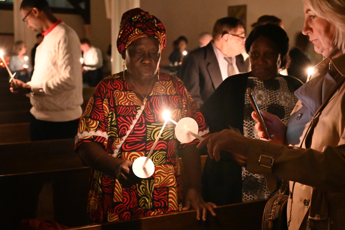 Two members of the congregation light candles